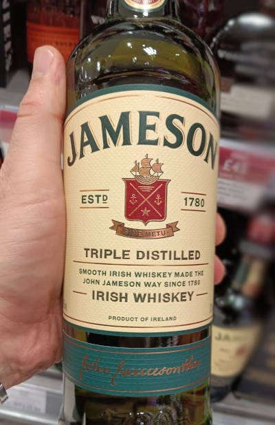 Andrew holding a bottle of Jameson Irish Whiskey